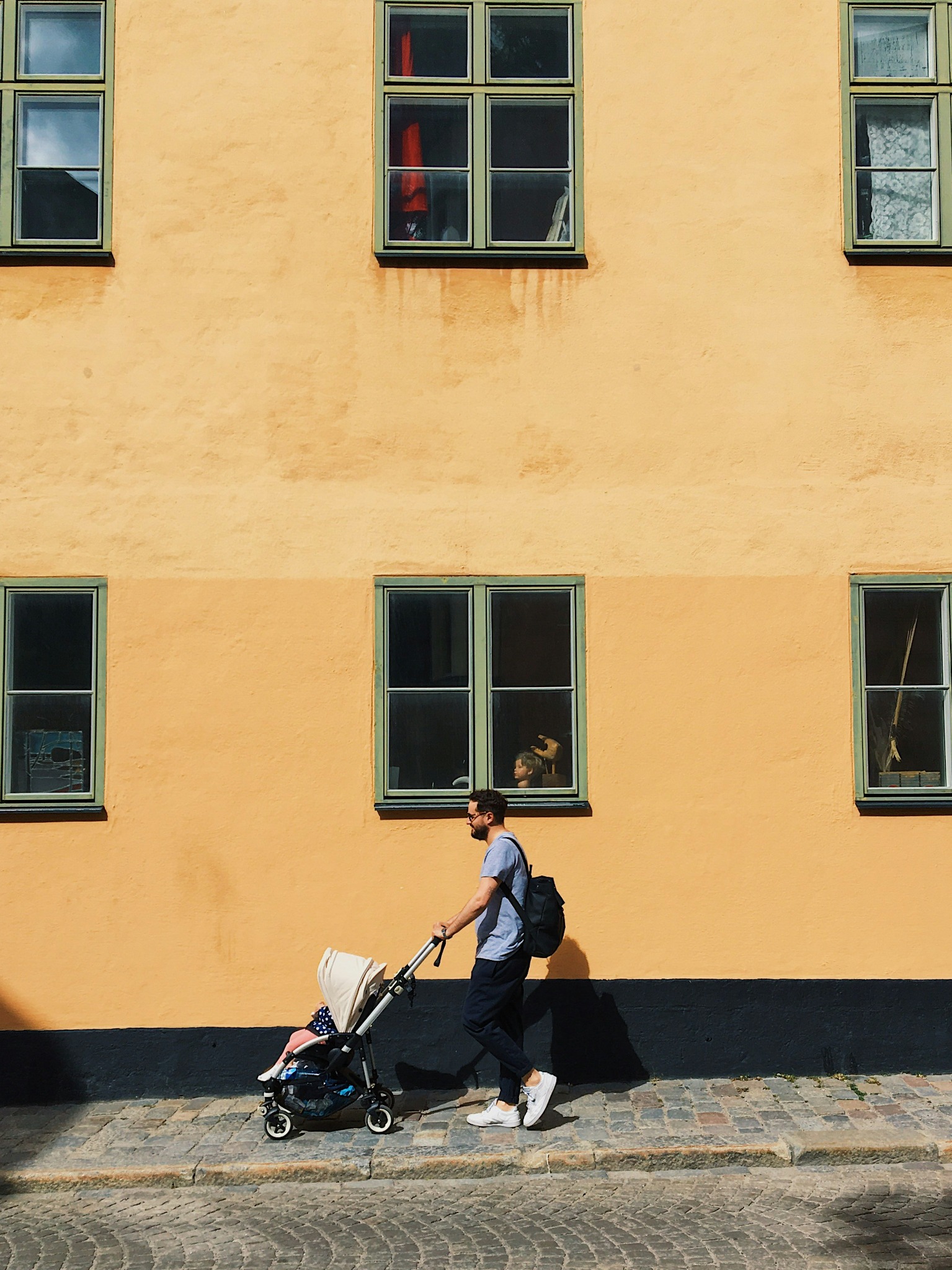 Parent walking with a child in a buggy
